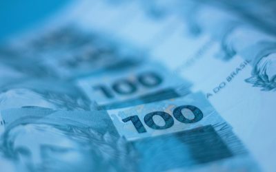 Blurred close-up view of Brazilian 100 real banknotes, showcasing currency details.